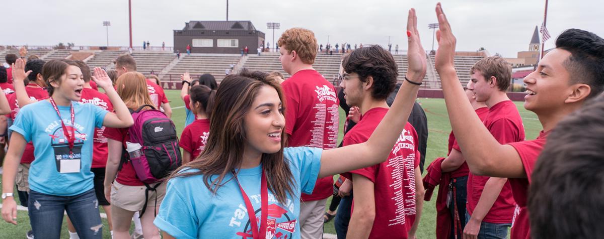 Students high-five at orientation